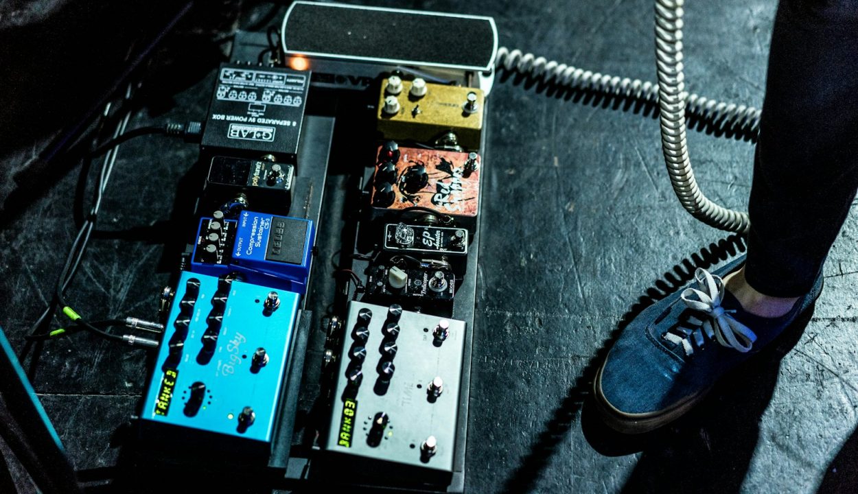 person standing beside assorted-color guitar tuner lot